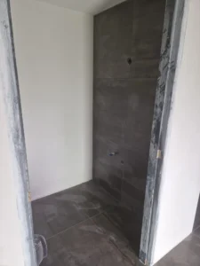 Doorlopende grote grijze tegels van vloer naar muur