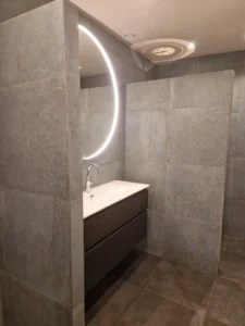 Badkamer tegels met wastafel en ronde spiegel